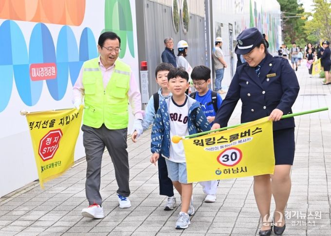 22일 이현재 하남시장(왼쪽)과 박주현 녹색어머니연합회장(오른쪽)이 청아초등학교 통학로에서 워킹스쿨버스 자원봉사에 참여하고 있다.