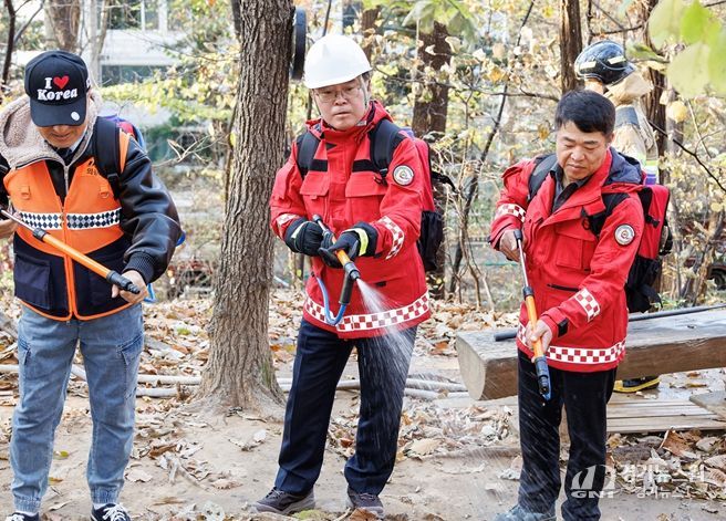 진교훈 서울 강서구청장(가운데)이 21일 오후 우장산 일대에서 열린 ‘유관기관 합동 산불진압훈련’에서 등짐펌프를 매고 산불진화대원과 함께 잔불진화작업을 하고 있다.