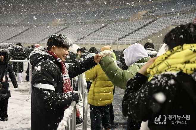 부천FC1995의 승강 PO 1차전이 폭설로 연기된 후 돌아가는 시민들과 조용익 부천시장이 주먹인사를 나누고 있다.